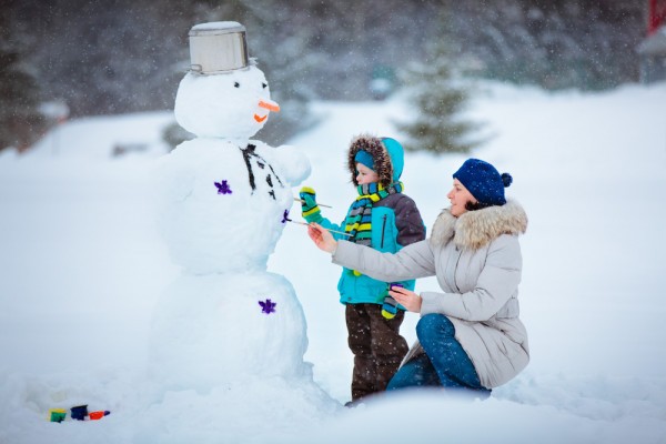 snowman making near the log cabin