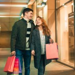 happy couple with shopping bags enjoying night city