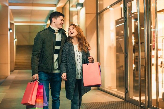 happy couple with shopping bags enjoying night city