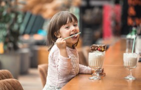 charming funny little girl drinks milkshake