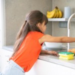 cute little girl washing dish kitchen by herself child reaching kitchen sink faucet tap turning water 74855 8029