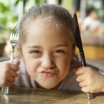 close up upset girl holding cutlery