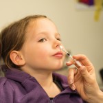 Photo of child being administered influenza vaccine live attenuated nasal 2