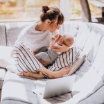 young mother with her kid working home computer