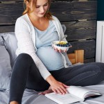 pregnant woman eating reading book
